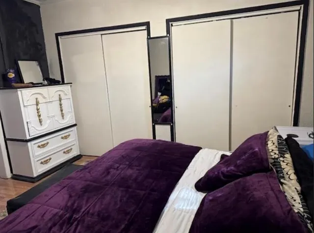 a bedroom with a bed and a mirror on the wall