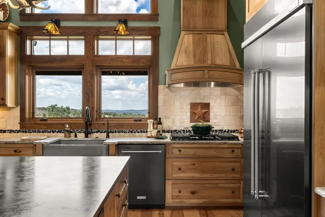 a kitchen with a stove a refrigerator and windows