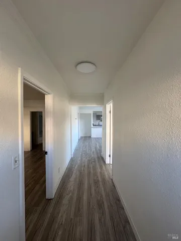 a view of a hallway with wooden floor and staircase