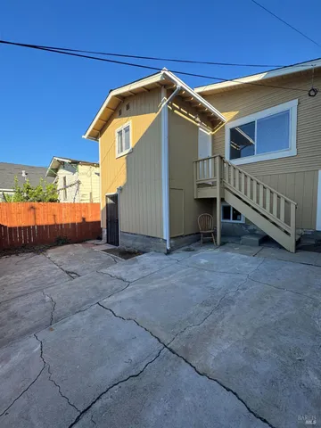 a view of a house with backyard and wooden fence