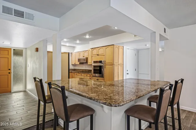 a kitchen with stainless steel appliances granite countertop a sink a stove and cabinets