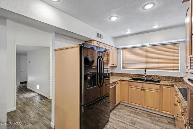 a kitchen with stainless steel appliances granite countertop a sink stove and cabinets