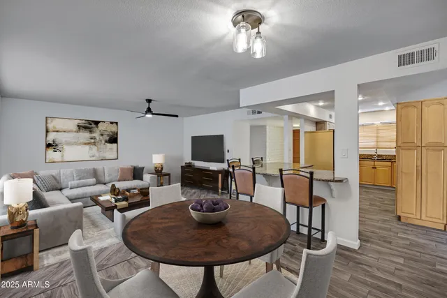 a living room with furniture a flat screen tv and kitchen view