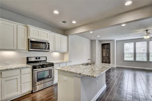 a kitchen with granite countertop a sink and steel appliances
