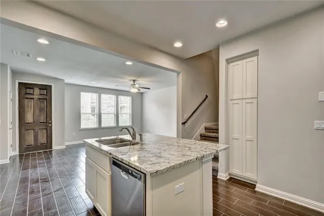 a kitchen that has a sink and a wooden floor