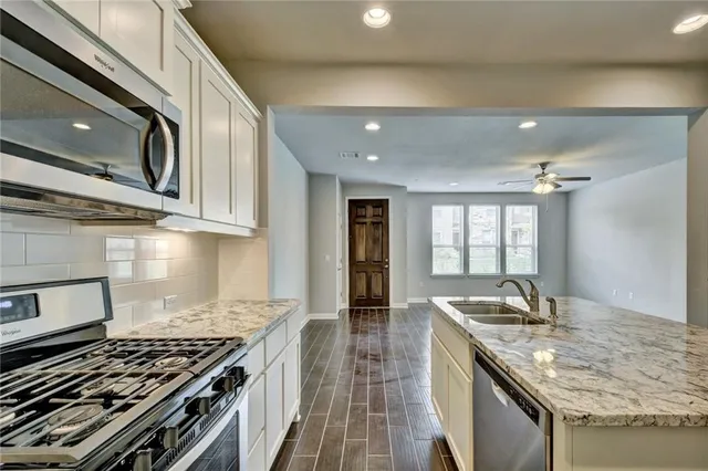 a kitchen with stainless steel appliances granite countertop a stove and a sink
