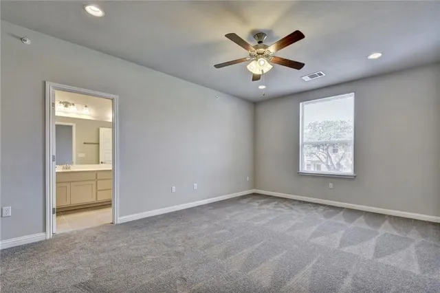 an empty room with fan and windows