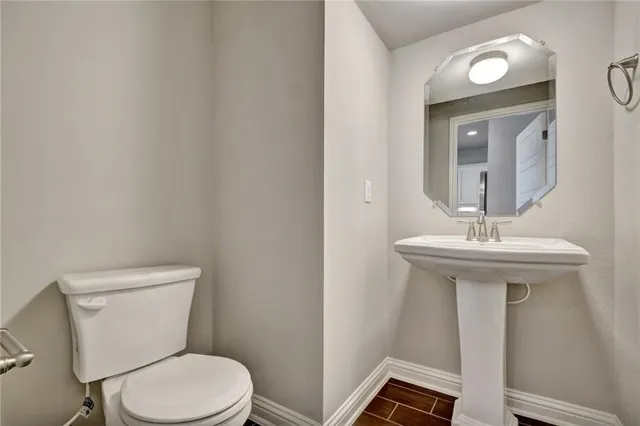 a bathroom with a toilet a sink and mirror