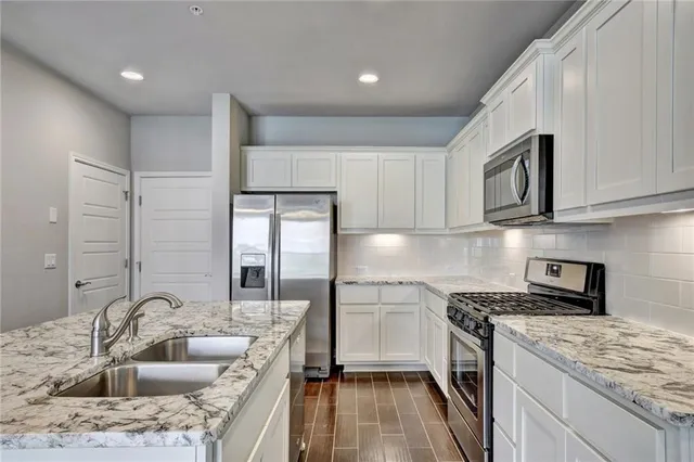 a kitchen with a sink stove top oven and refrigerator