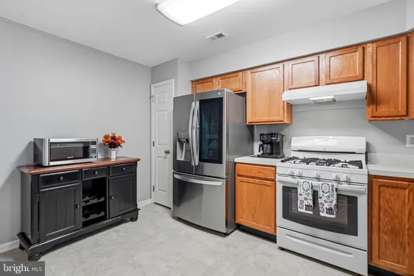 a kitchen with stainless steel appliances granite countertop a stove a sink and a refrigerator