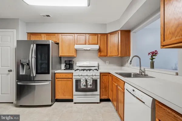 a kitchen with stainless steel appliances granite countertop a refrigerator and a stove top oven