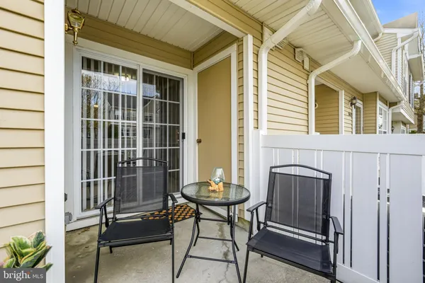 a view of a patio with table and chairs with wooden fence and plants