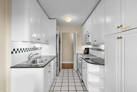 a kitchen with granite countertop a sink stove and refrigerator