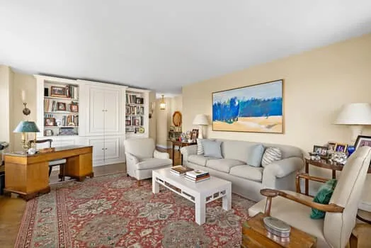 a living room with furniture a rug and a table