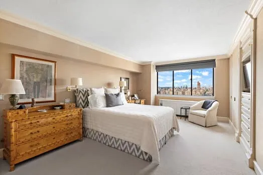 a bedroom with a bed and large windows