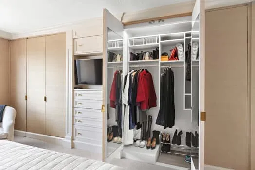 a view of walk in closet with clothes and shoes