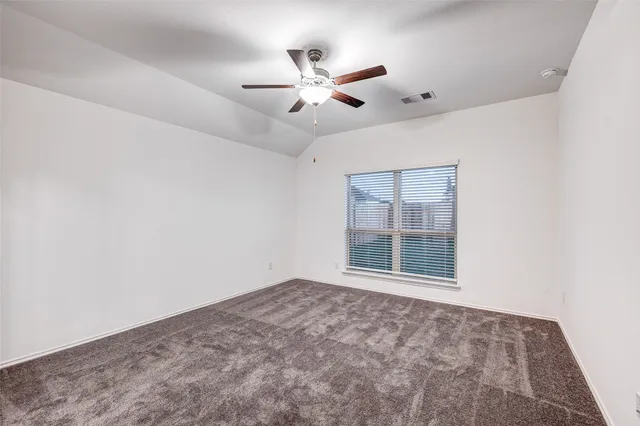 an empty room with window and ceiling fan