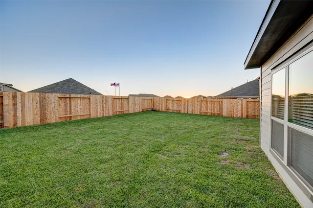 a view of a backyard with wooden fence