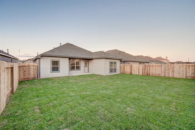 a view of a yard in front of a house with large trees