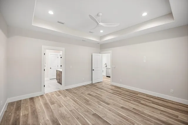 a view of an empty room with window wooden floor and closet