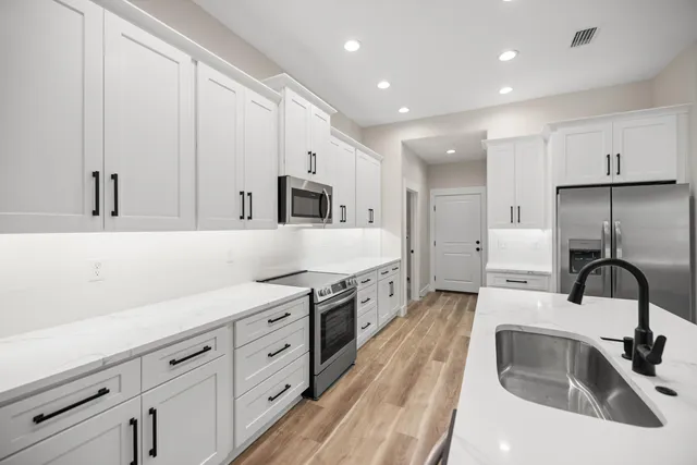 a kitchen with white cabinets and stainless steel appliances