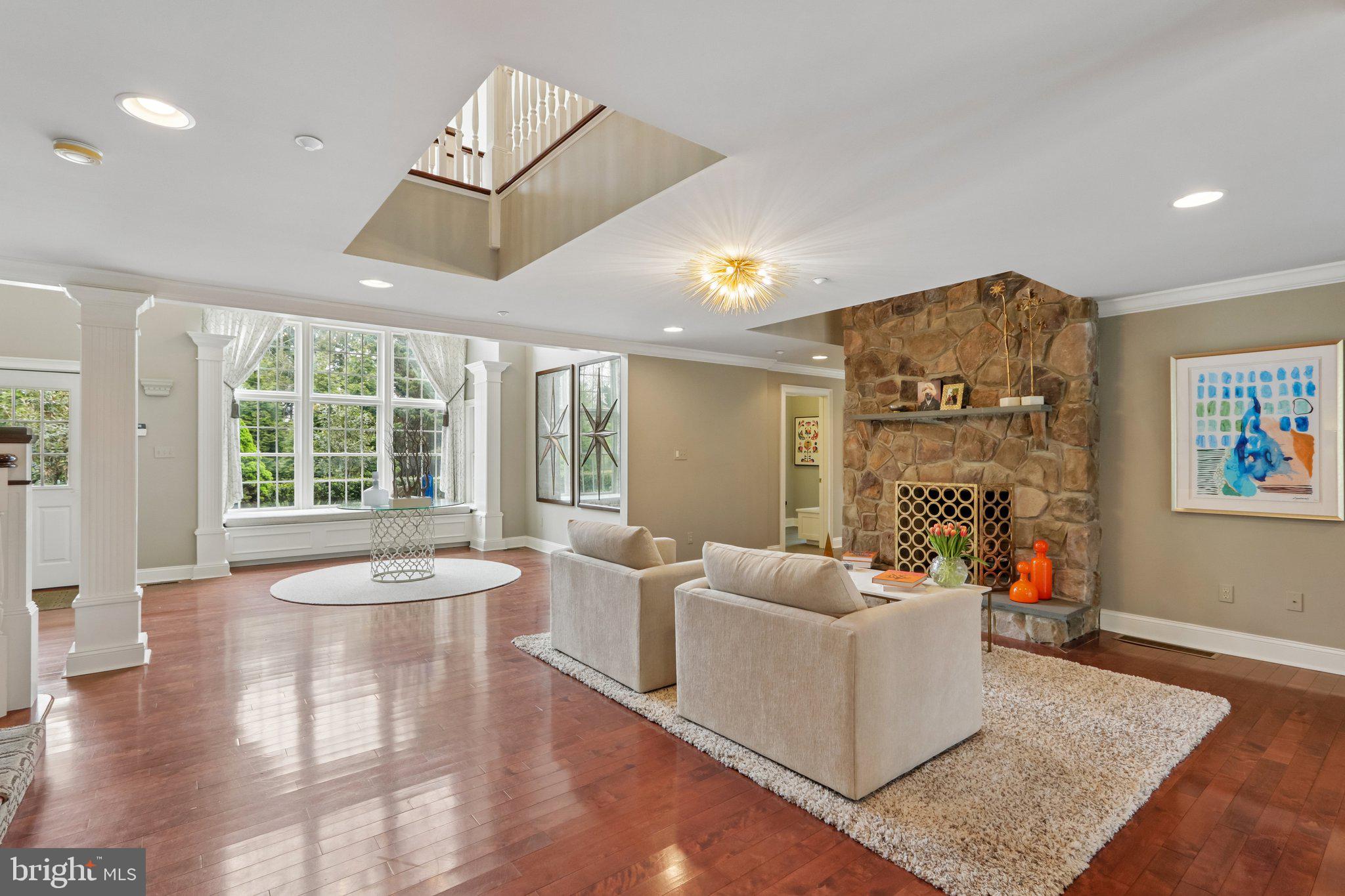 209 Welsh Road Ambler, PA 19002 - Photo 5 of 80 a living room with furniture a fireplace and a floor to ceiling window