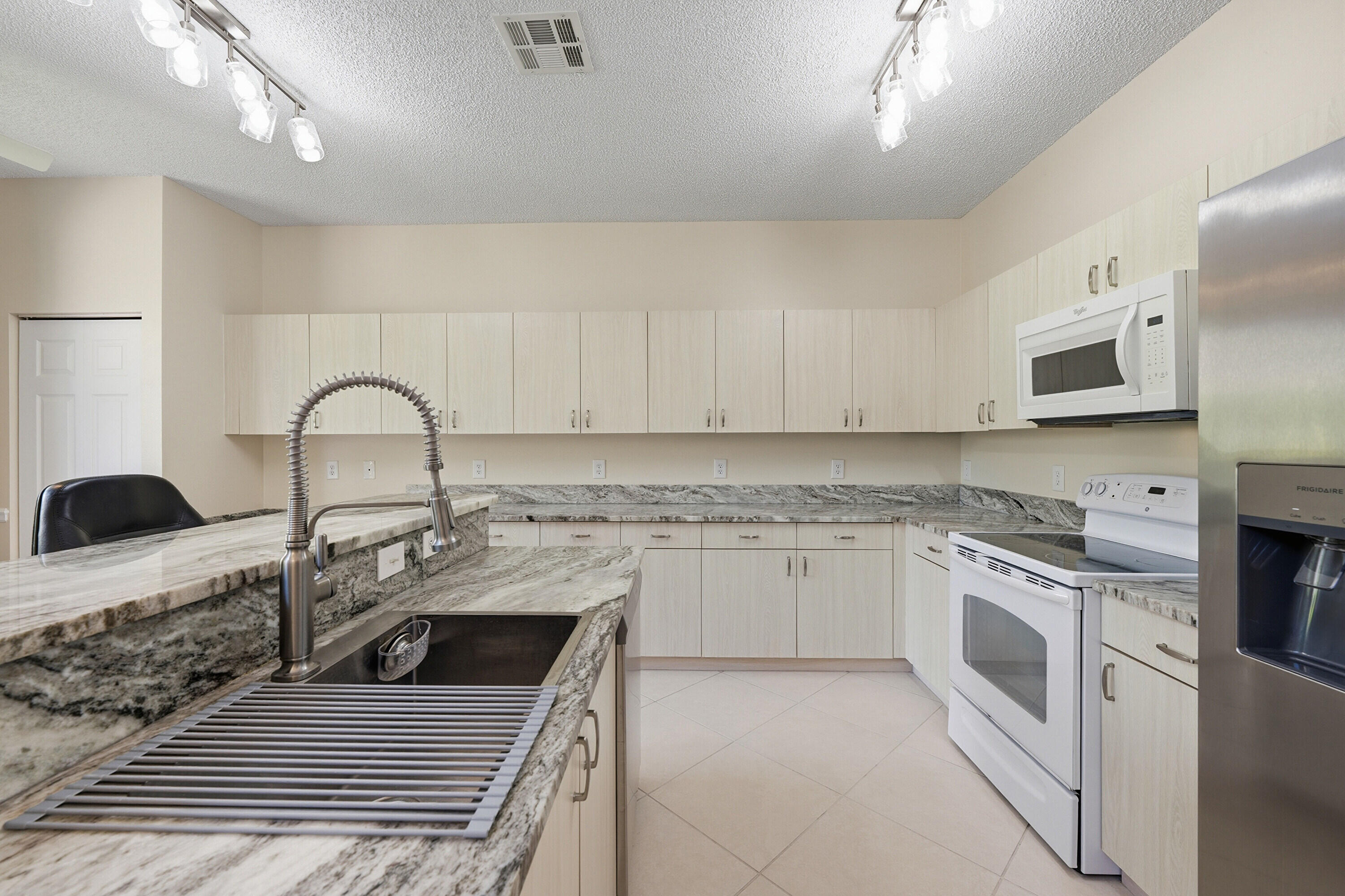 18474 Old Princeton Lane Boca Raton, FL 33498 - Photo 18 of 46 a kitchen with stainless steel appliances granite countertop a sink a stove top oven a counter space and cabinets