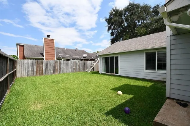 a view of a backyard with table and chairs and wooden fence