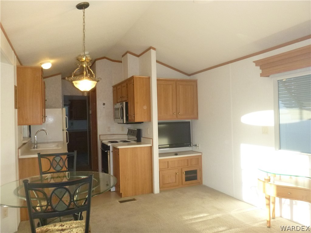 2000 South Ramar Road, Unit 688 Bullhead City, AZ 86442 - Photo 16 of 20 a kitchen that has a microwave a stove and a refrigerator