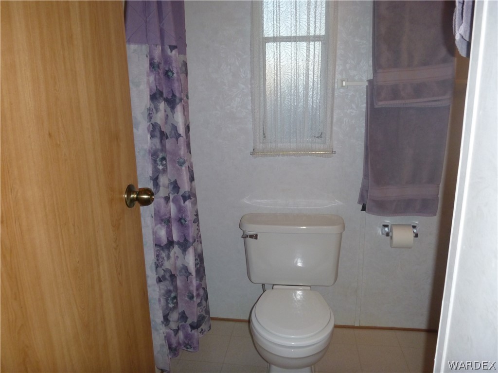 2000 South Ramar Road, Unit 688 Bullhead City, AZ 86442 - Photo 10 of 20 a white toilet sitting next to a shower curtain