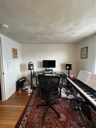 a living room with furniture and a piano