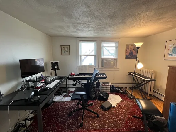 a view of a workspace with furniture and a window