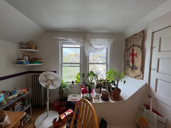 a living room with furniture chess table and a potted plant