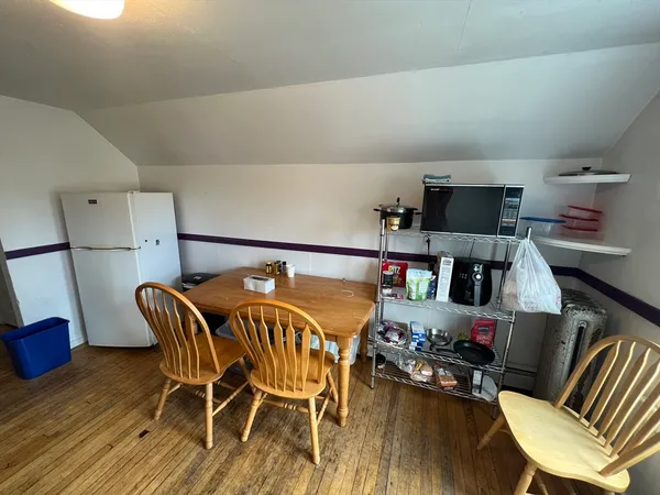 a kitchen with stainless steel appliances granite countertop a refrigerator a stove and a wooden floor