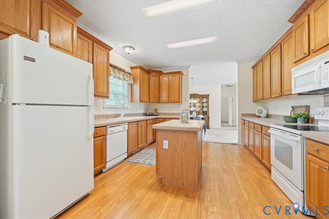 28231 Lewis Moore Road Ruther Glen, VA 22546 - Photo 12 of 50 a kitchen with a refrigerator a stove top oven a sink dishwasher and white cabinets with wooden floor