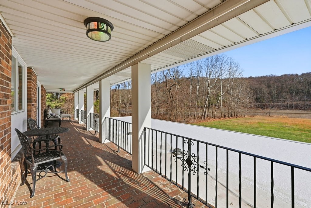 1430 Magnolia Road Southwest Dellroy, OH 44620 - Photo 18 of 50 Expansive covered balcony with peaceful views — the perfect place to relax and enjoy the outdoors.