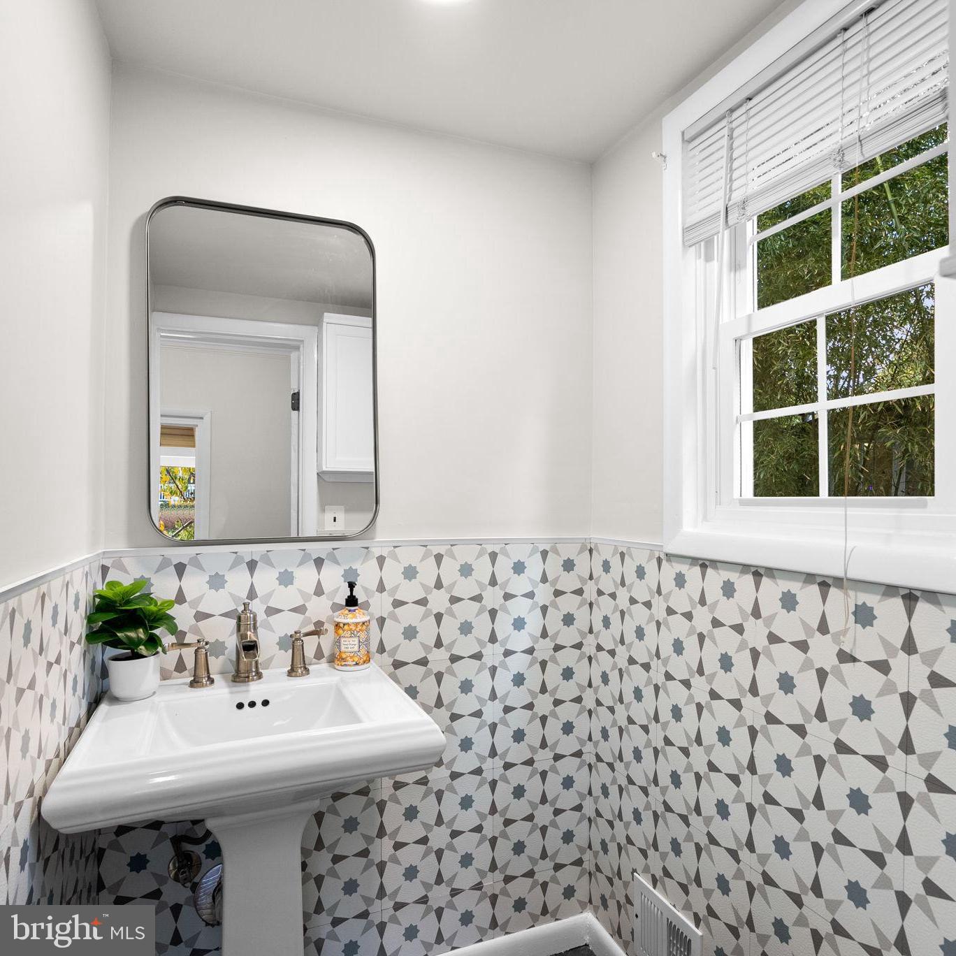 725 Silver Spring Avenue Silver Spring, MD 20910 - Photo 14 of 41 a bathroom with a sink a mirror and a shower