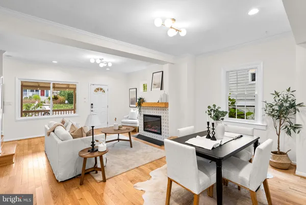 a living room with fireplace furniture and dining table
