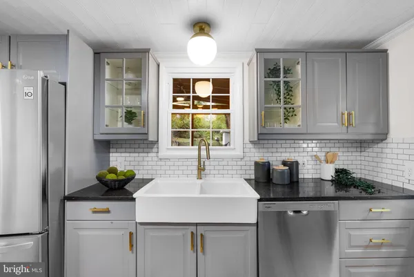 a kitchen with stainless steel appliances a sink a refrigerator and a window