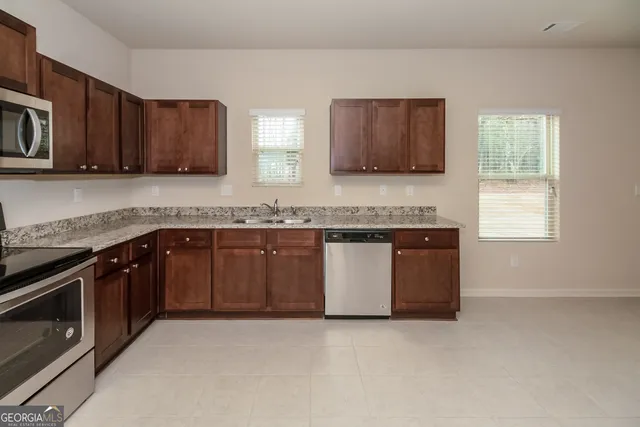 a kitchen with stainless steel appliances granite countertop a stove a sink and a microwave