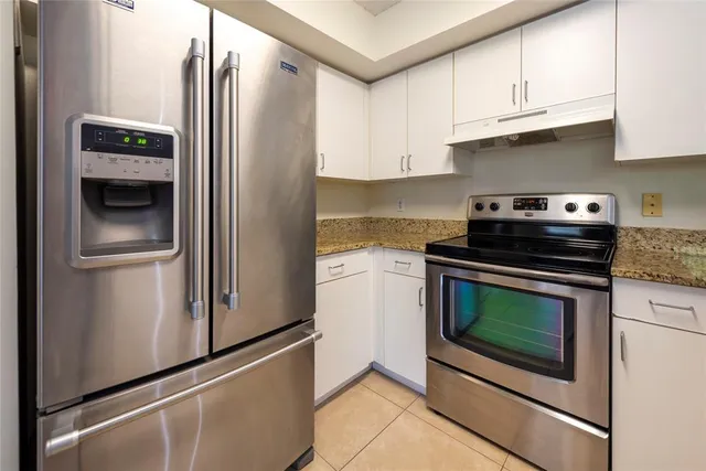 a kitchen with stainless steel appliances granite countertop a refrigerator sink and stove