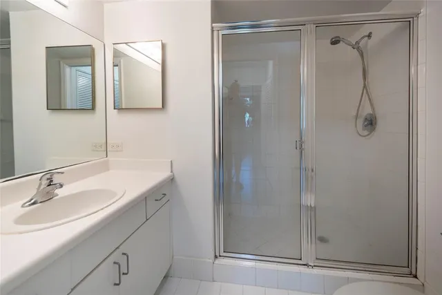a bathroom with a shower sink and mirror