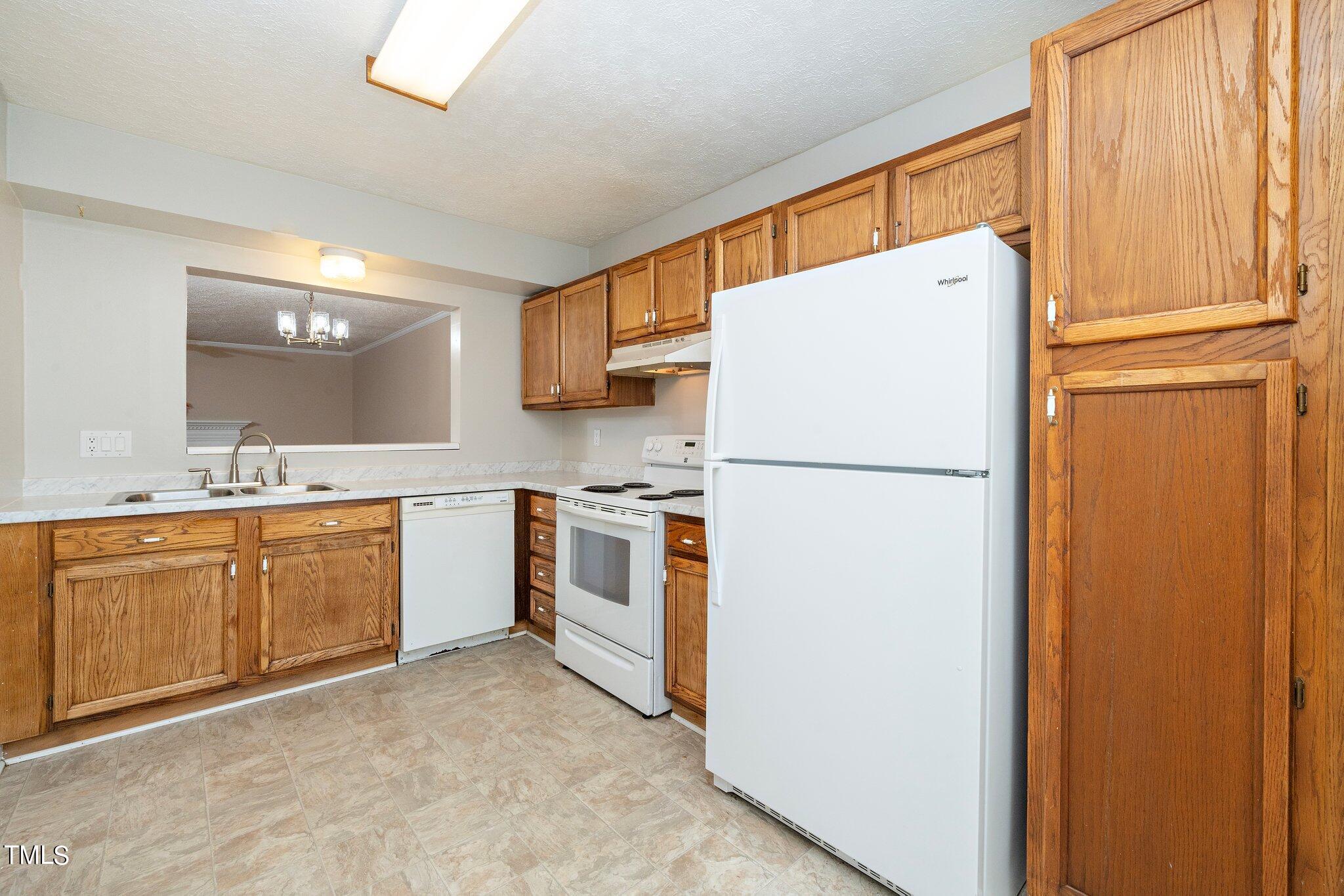604 Broad Leaf Circle Raleigh, NC 27613 - Photo 5 of 23 a kitchen with sink refrigerator and cabinets