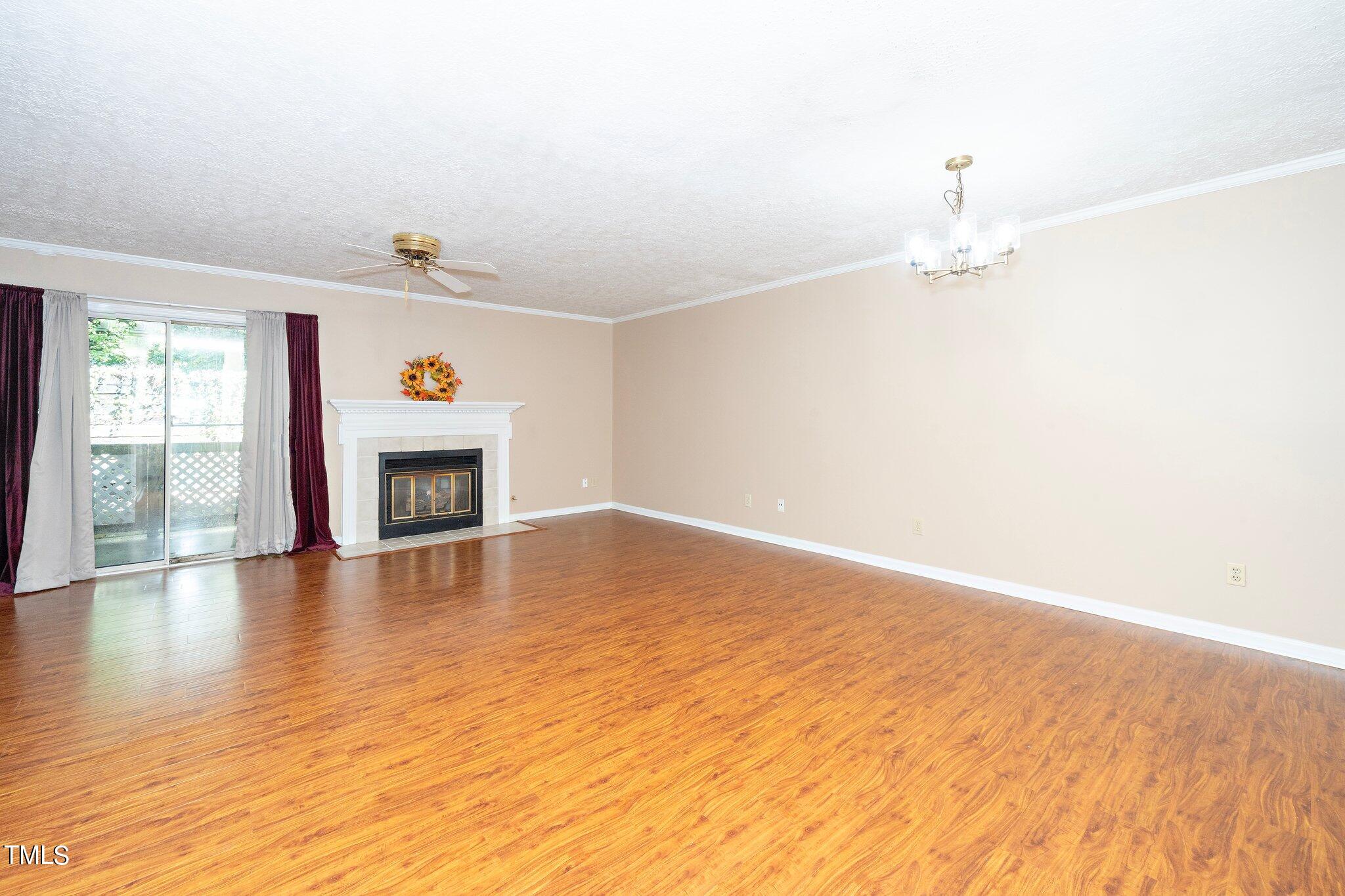 604 Broad Leaf Circle Raleigh, NC 27613 - Photo 8 of 23 a view of empty room with wooden floor and fireplace