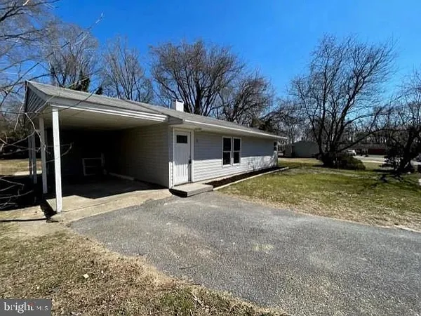 a view of a house with backyard and trees