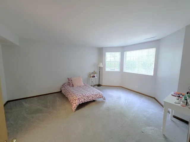 a spacious bedroom with a bed and a window
