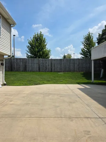 a view of backyard with potted plants and wooden fence