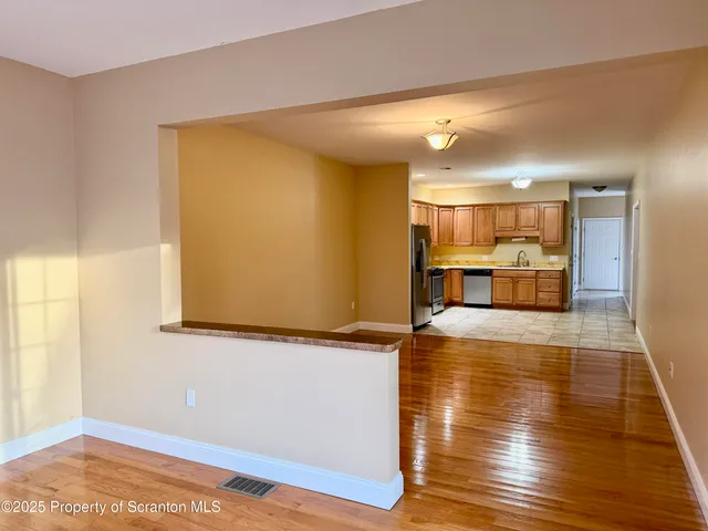 a view of empty room with wooden floor