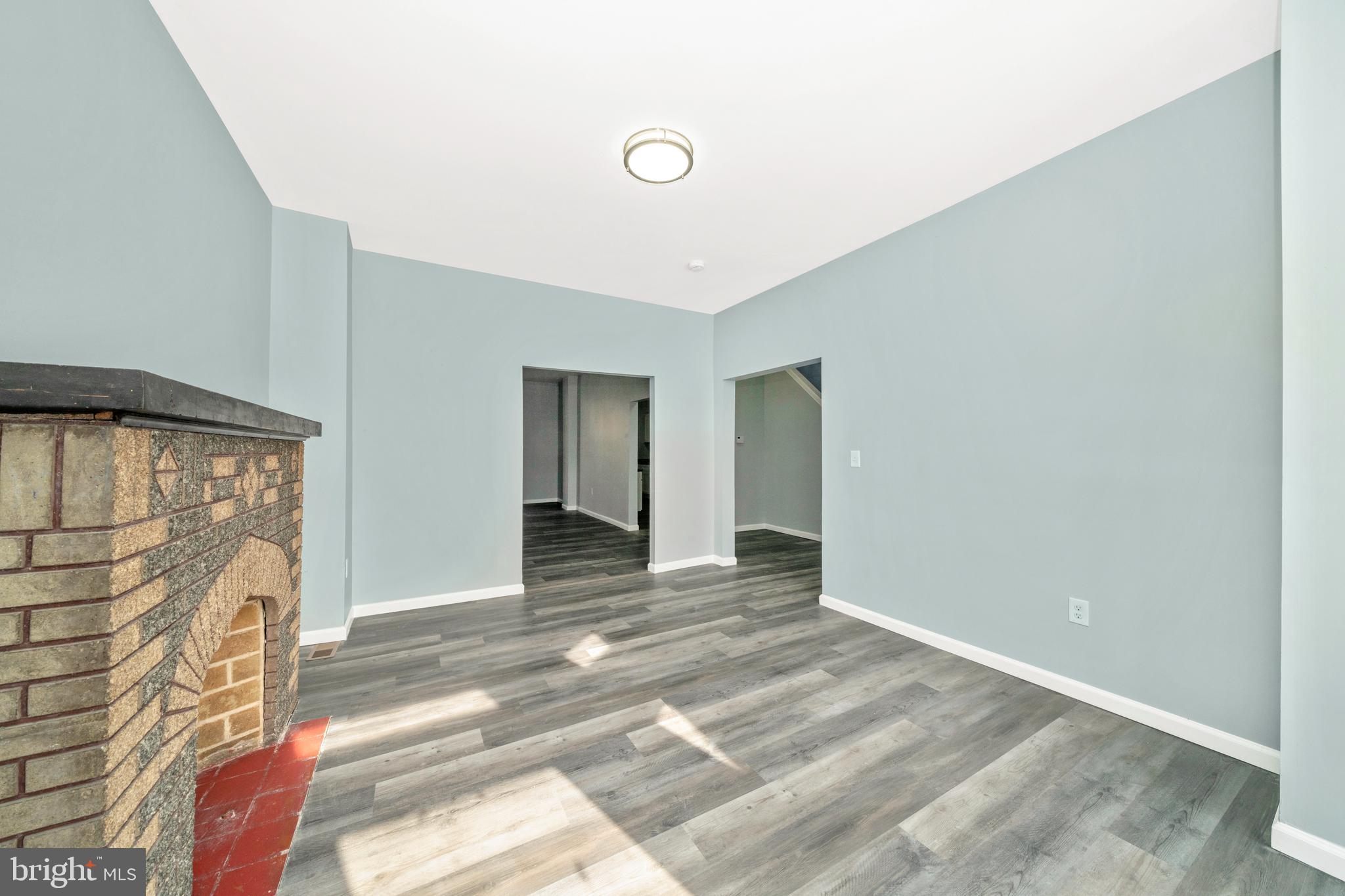2318 West Lanvale Street Baltimore, MD 21216 - Photo 4 of 37 a view of a livingroom with wooden floor and a ceiling fan