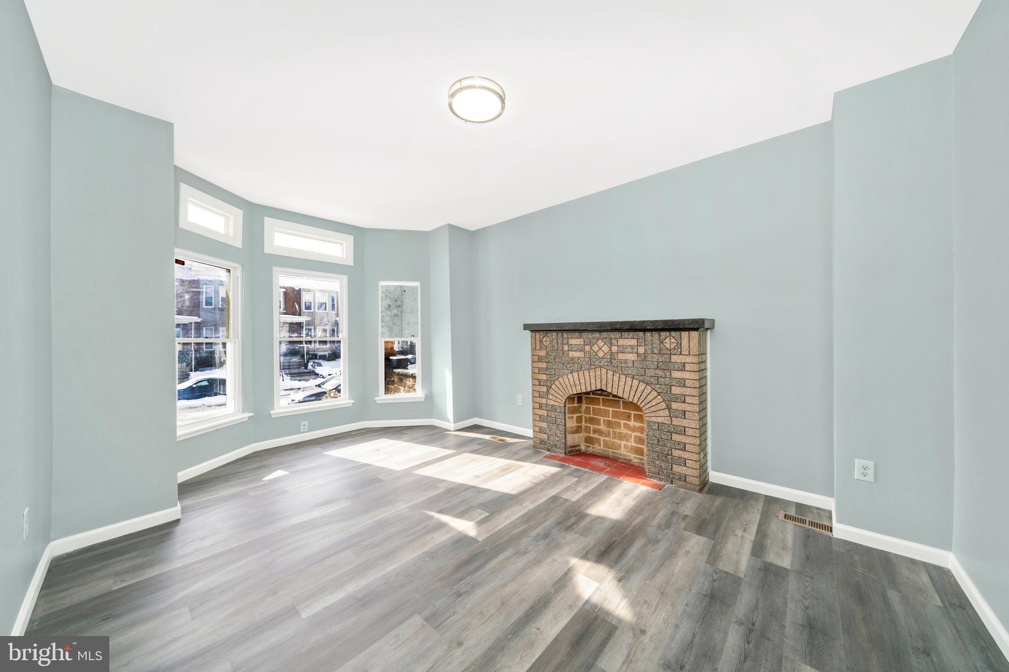 2318 West Lanvale Street Baltimore, MD 21216 - Photo 5 of 37 an empty room with windows and fireplace